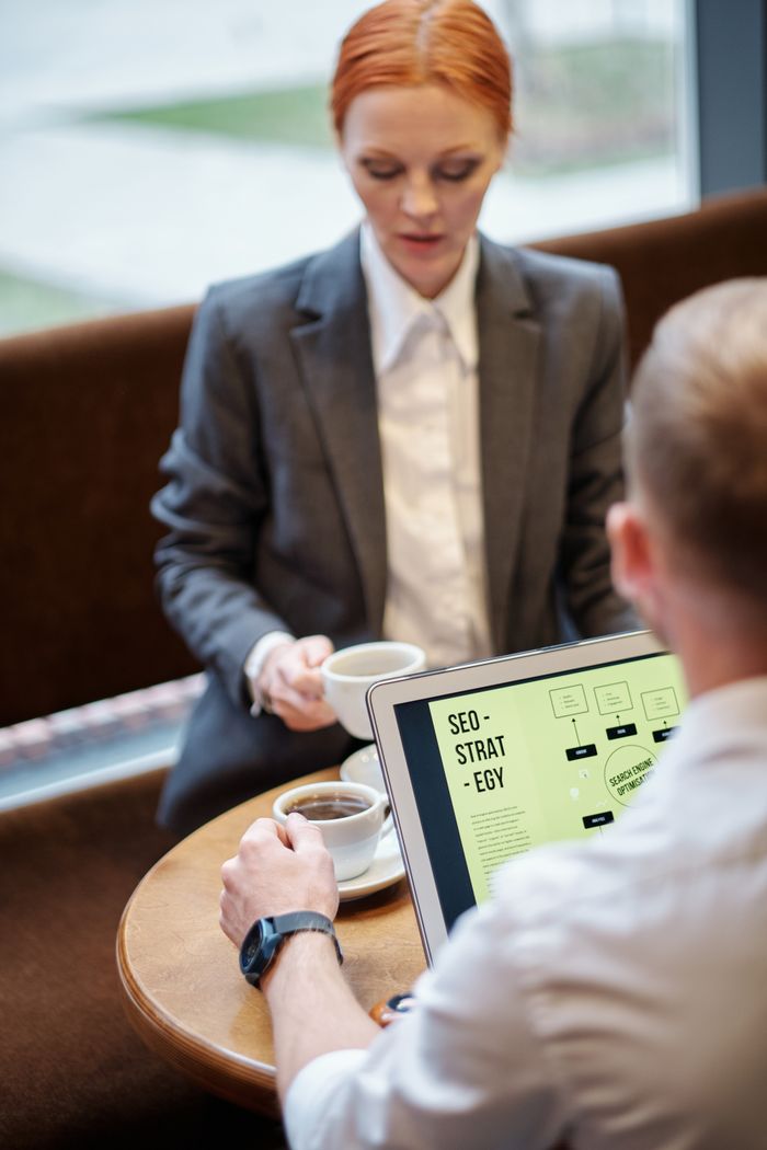 Réunion professionnelle dans un café avec un ordinateur portable présentant une stratégie SEO. Idéal pour des concepts business.